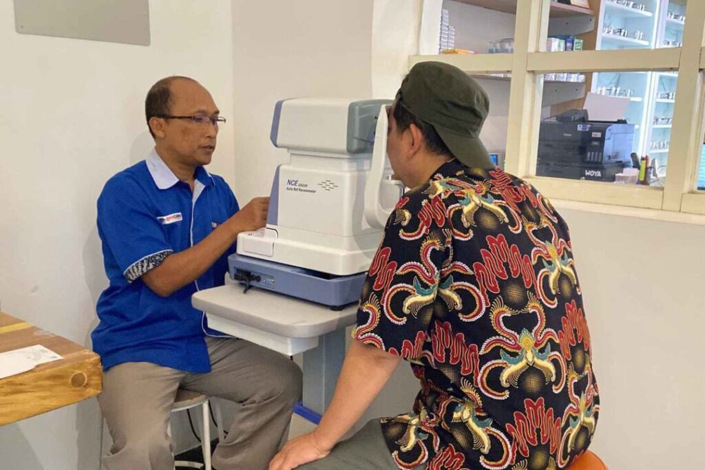 Pegawai optik sedang periksa mata